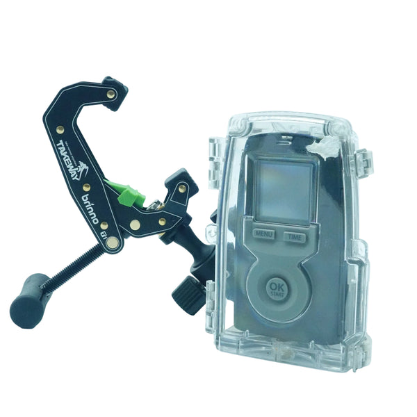 A black and green mounting bracket with gold screws and a black rubber foot, shown next to a gray digital camera housed in a clear protective waterproof case on a white background.